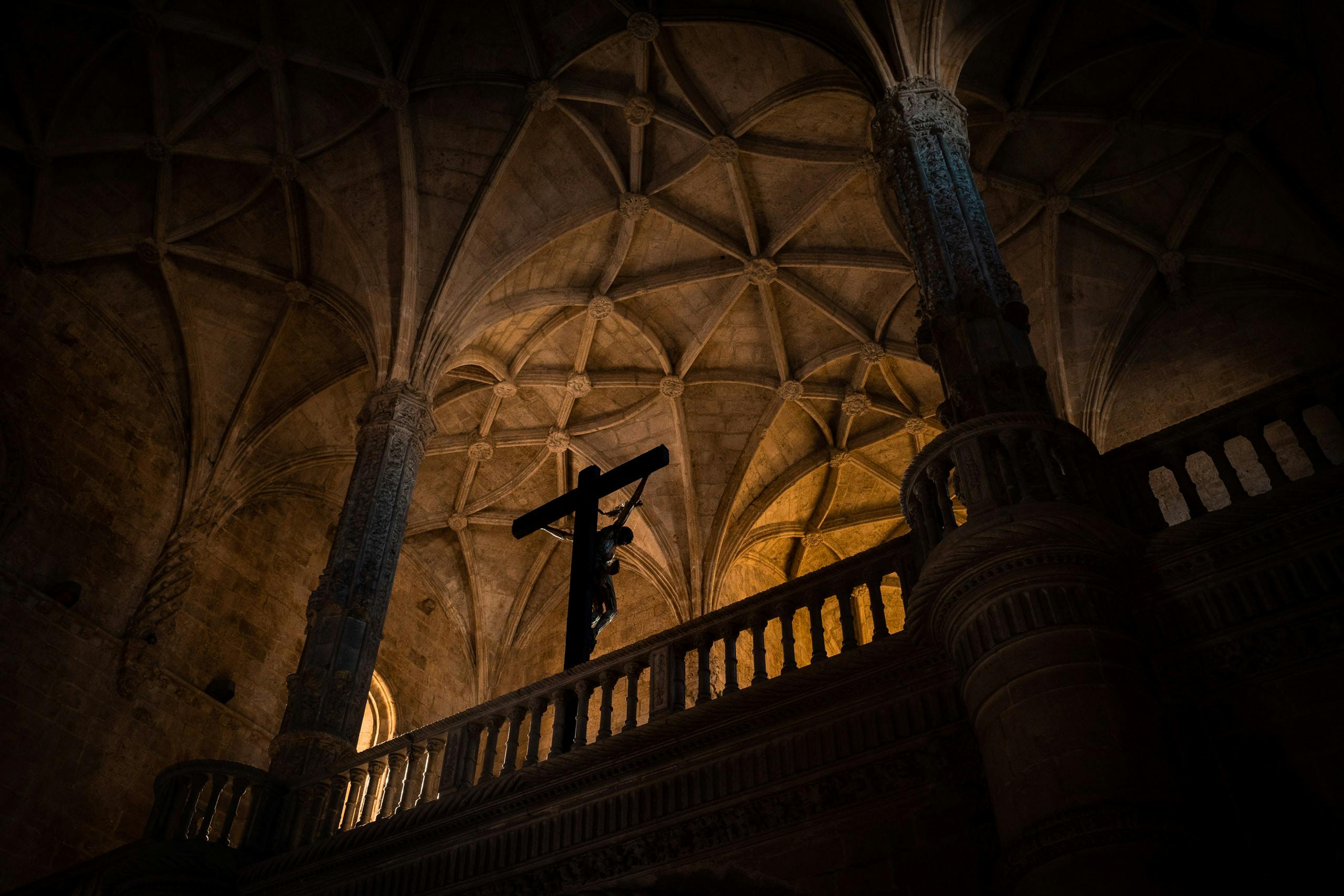 View from below of Jesus on cross inside a monastery