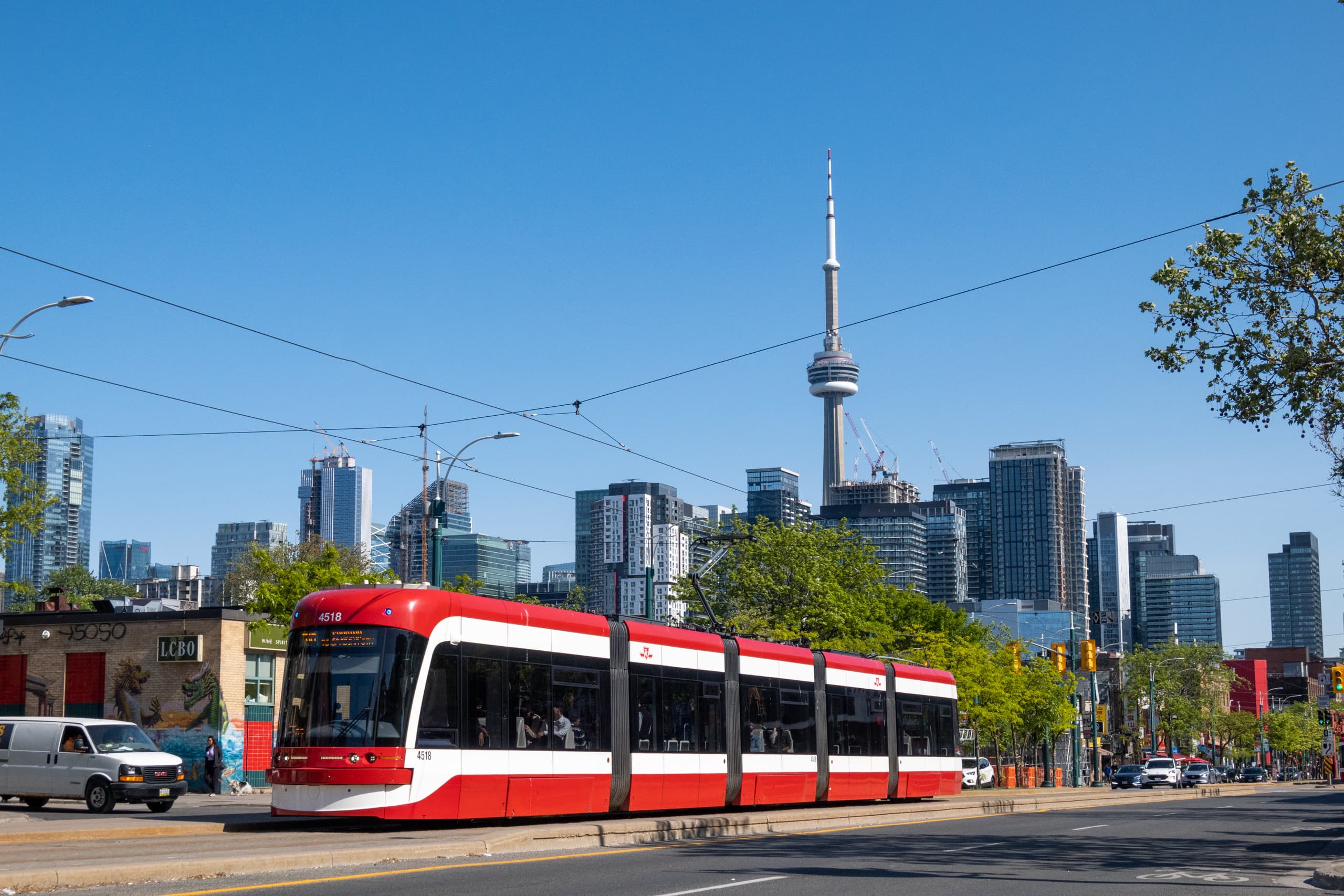 A red street car in the front and CN Tower in the background