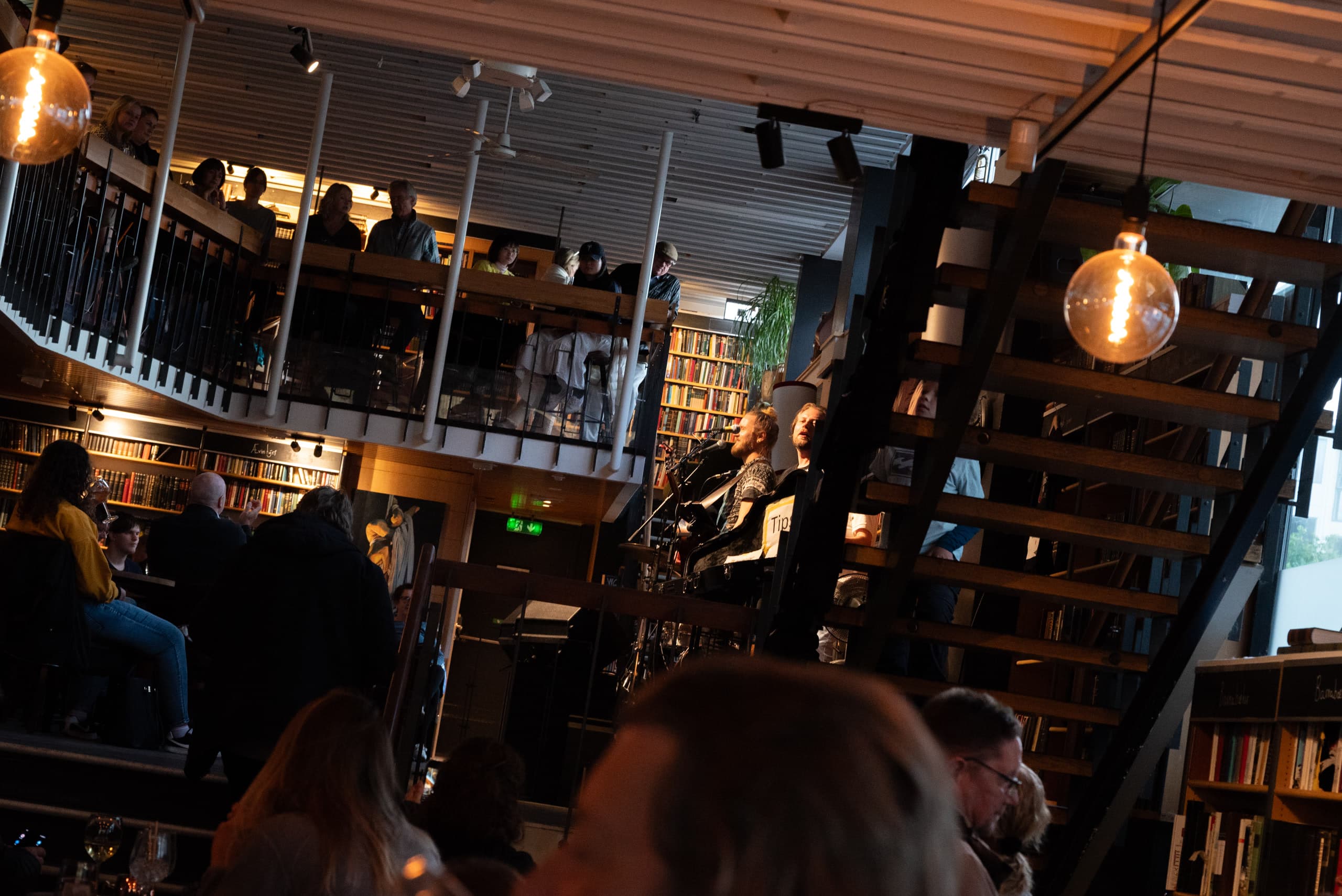 People watching a band playing inside a bookstore café